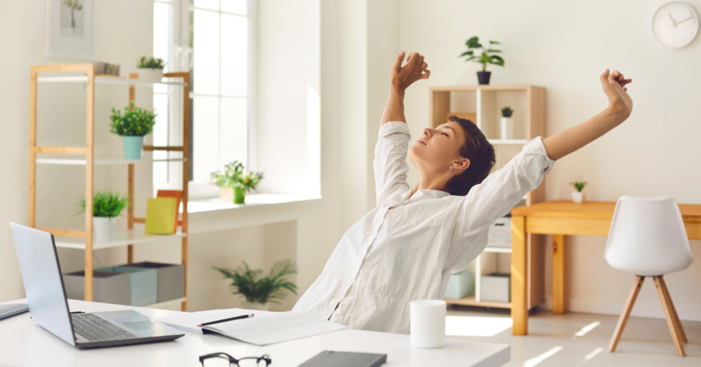 Woman showing a desk stretch at work, promoting Desk Stretches for a Healthier Workday